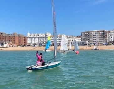 lady waving from sailing dinghy